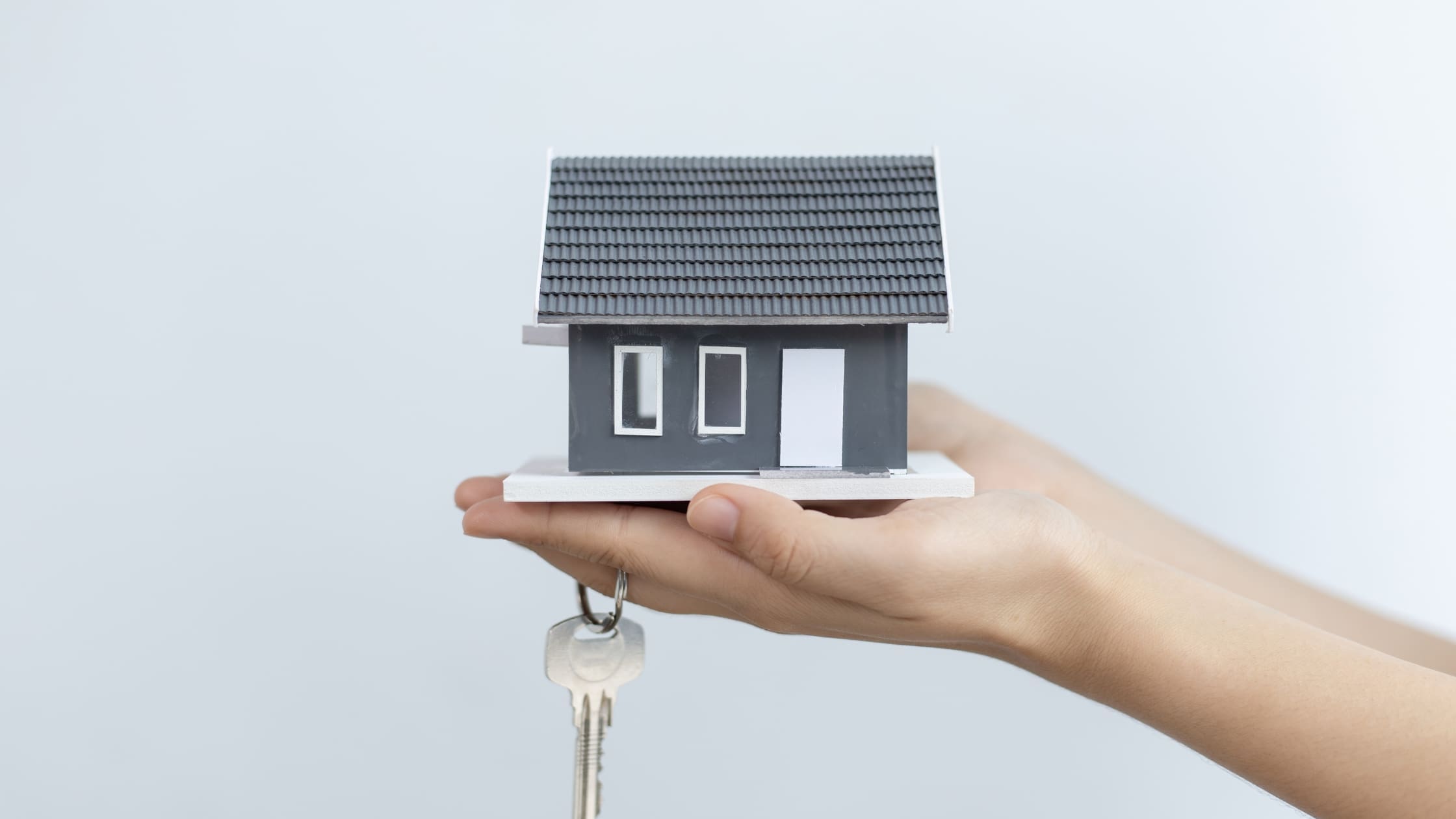 Hand holding a small house